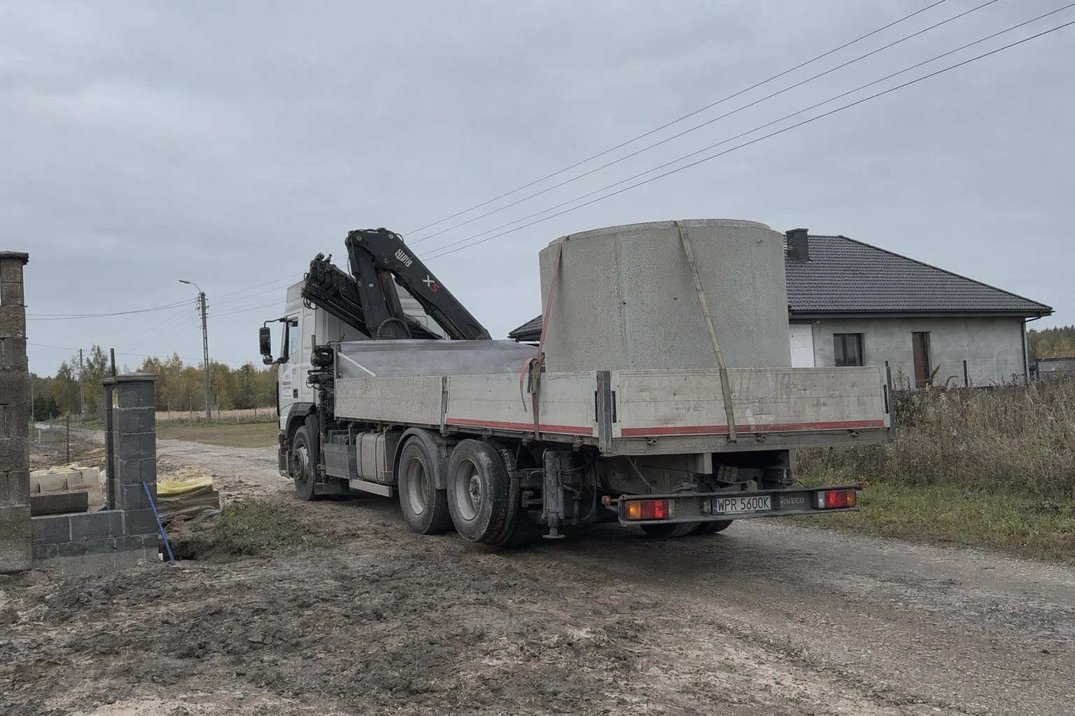 Samochód z HDS przewożący betonowe kręgi na drodze w Mazowieckiem